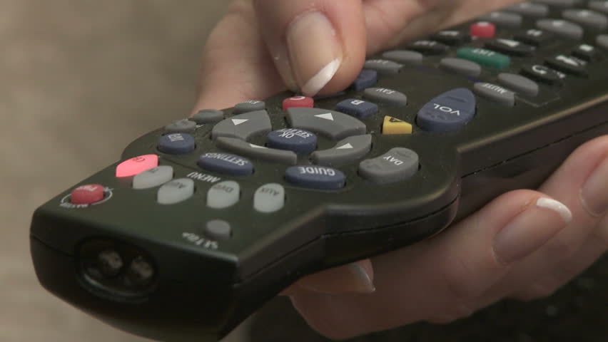 Close up of woman's hands on TV remote control