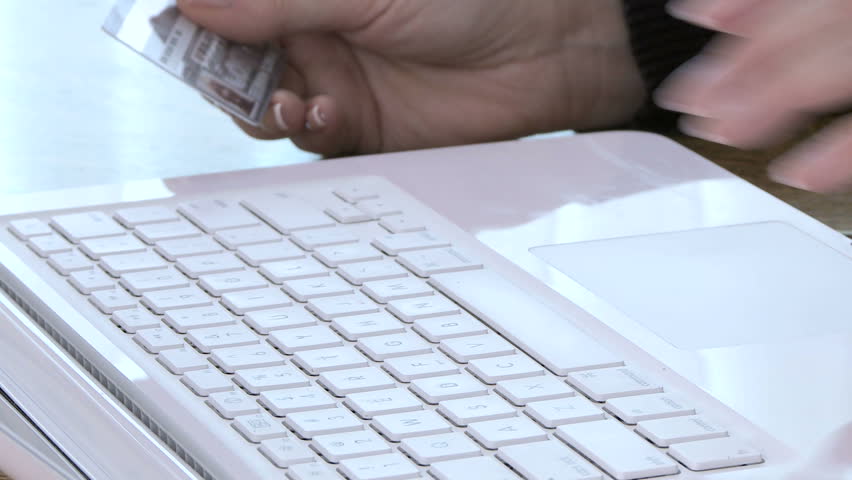 Close up of woman's fingers typing on laptop keyboard making online purchase