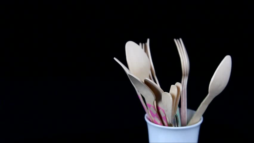 Rotating wood ice cream spoons on black background.