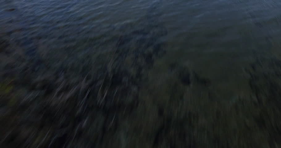 Aerial birds eye traveling across lake Michigan with a lift and reveal.