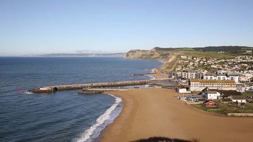 West Bay Dorset England uk pan view to west over small town on Jurassic coast south of Bridport on a beautiful day with blue sky and sea