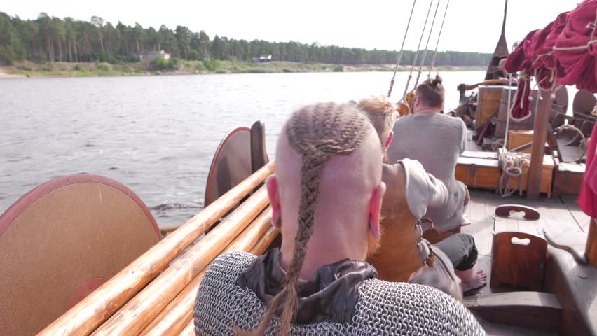 Vikings are floating on the river on the Drakkar
