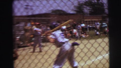 LYNBROOK, NEW YORK 1972: boy hits a fly ball in baseball outfielder catches and inning is over