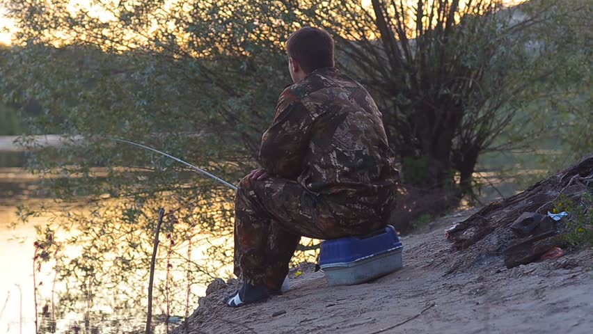 Man catches on a rod fish, in pure and transparent to the river