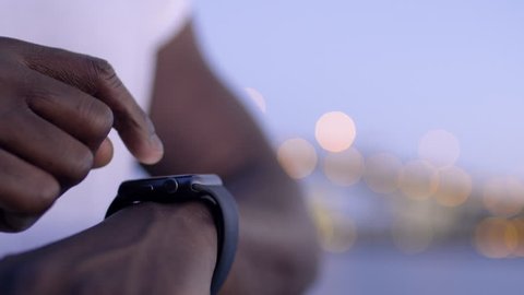 Closeup Of Man using His Smartwatch With City Lights In Background
