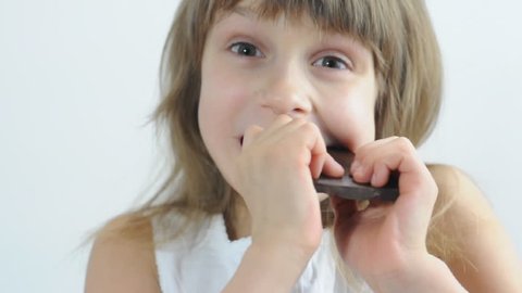 close-up portrait of a little girl eating chocolate