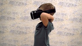 Boy use virtual reality headset helmet. VR. Virtual reality. 4K resolution. New technology. Hi-tech. High technology. Virtual reality glasses. 