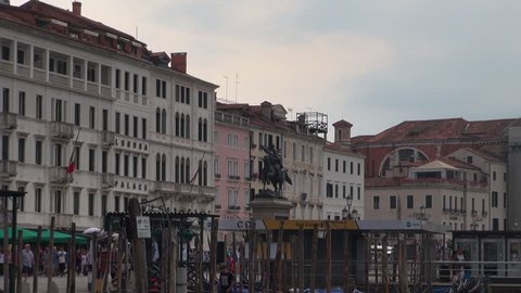 Venice, Italy, circa 2016:Shot of venetian buildings on the edge of the canal. The buildings all have docks leading out to the water. A boat is visible as well.50 fps, real time