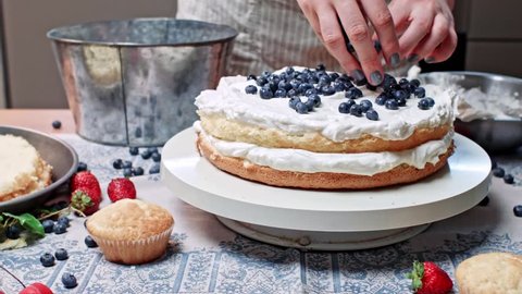 Girl makes cake, putting blueberry on shortcake, sequence of close ups