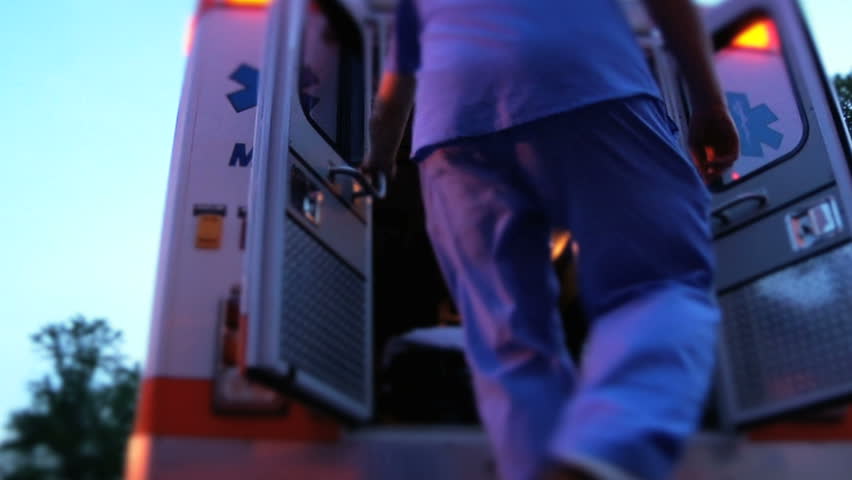 Emergency medical worker in hospital stepping into ambulance to make an emergency medical call for the coronavirus Royalty-Free Stock Footage #19985902