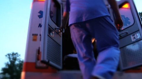 Emergency medical worker in hospital stepping into ambulance to make an emergency medical call for the coronavirus