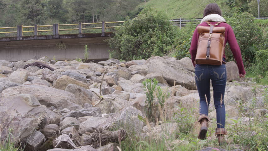 Travelling woman hiking on rocks