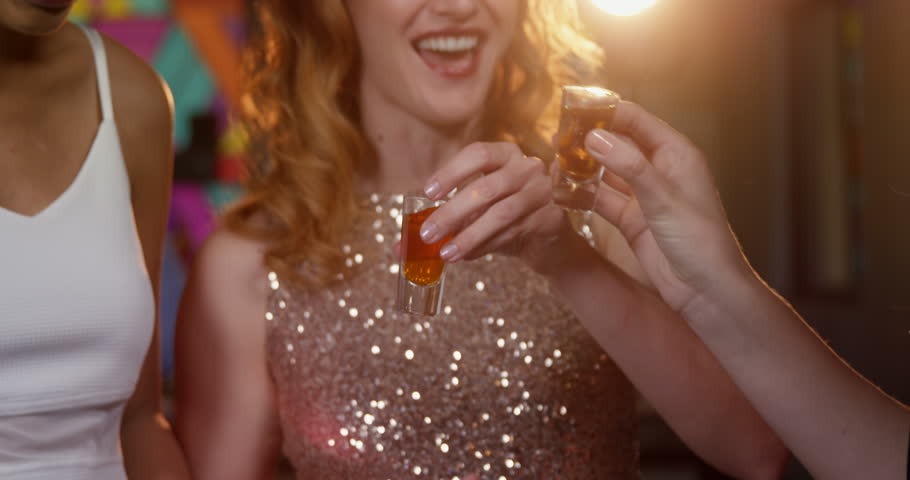 Happy friends toasting tequila in bar 4k