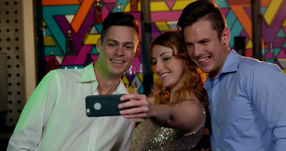 Friends taking selfie from mobile phone in bar 4k