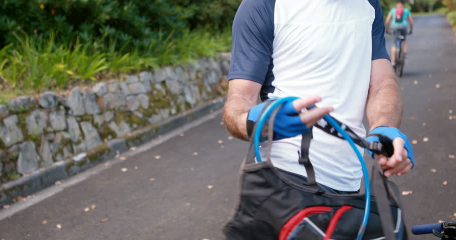 Male cyclist cycling on the road in park, 4k