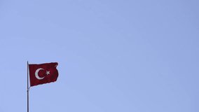 Turkish flag waving on a blue sky.