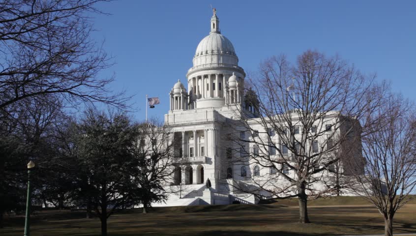 Providence Rhode Island State house on clear day in winter with trees with no leaves and flags flying, 1080 p HD 30 sec