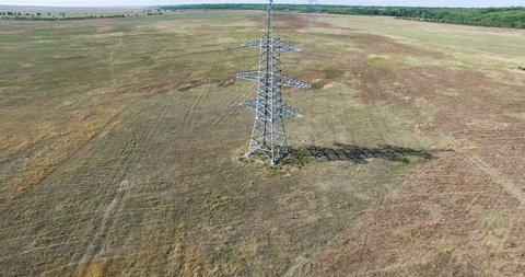 AERIAL: Flying up the high voltage electricity tower and power lines. Aerial drone shot. 4K 30fps