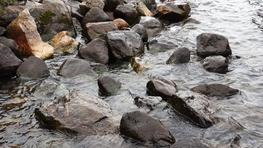 Waves washing across large rocks on the shore of Madeline Island in Lake Superior, Wisconsin, USA, for themes of repetition, time, and the environment