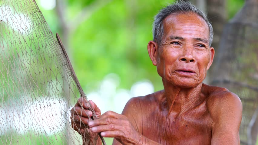 Asian man work and inspecting his fishing nets,inspecting work of fishing equipment.