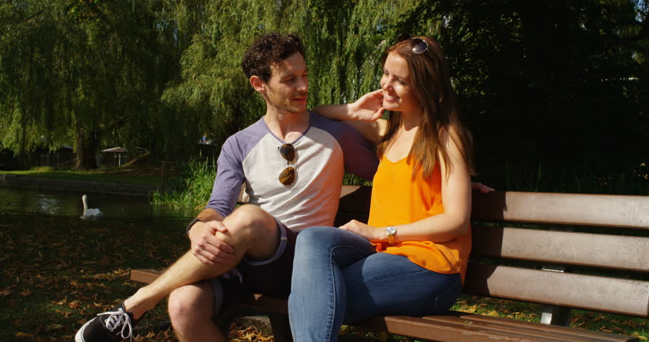 4k, Couple on a date sitting on a bench in the park. Slow motion.