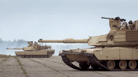 GAIZIUNAI, LITHUANIA - JUNE 18, 2015: M1A2 Abrams tanks in the military base. Two tanks against smoke background during NATO exercise Saber Strike 2015.