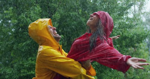 A couple, man and woman in love  dancing, kissing and playing happy smiling under the rain in the nature. freedom and  love. Concept of love, nature, happiness, freedom.