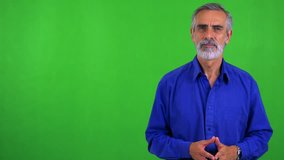 old senior man talks to camera - green screen - studio