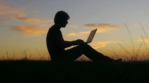 Remote work sitting outdoor at sunset วิดีโอสต็อก