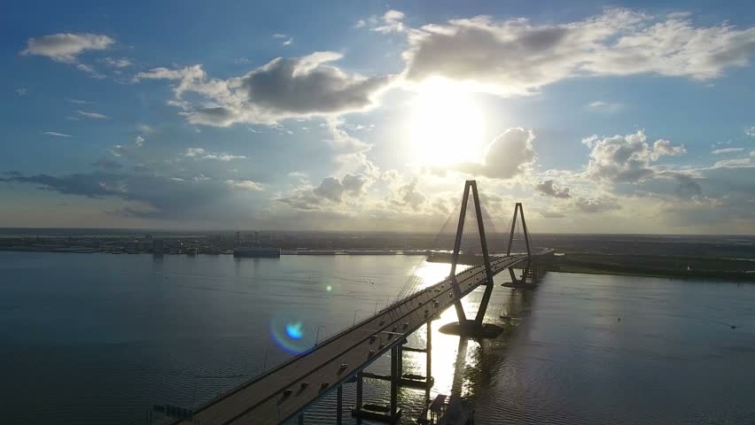 4k Cinematic Epic Aerial of Cargo Ships in Charleston SC Harbor. Done flying over Arthur Ravenel Jr. Bridge at sunset. Global ship trade in South Carolina. 