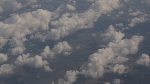 A view of the land and clouds from the airplane window.