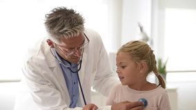 Doctor examining little girl with stethoscope