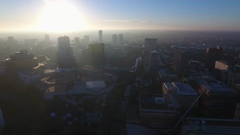 Aerial view of the Birmingham skyline and canal at sunrise.