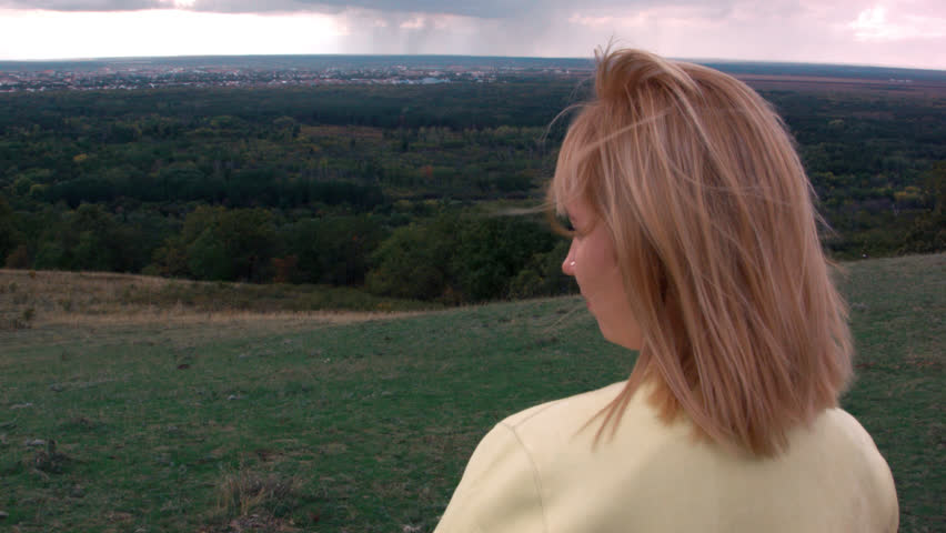 girl looks at the urban landscape from the hills
