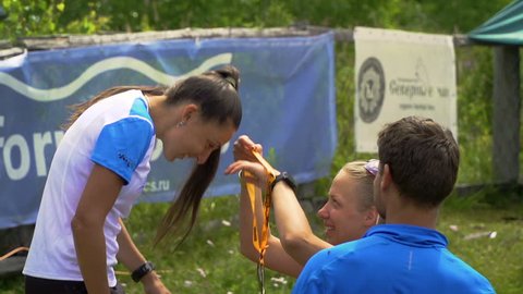 TUNGUR, RUSSIA - 07.2016: award ceremony of ALTAY ULTRA TRAIL.Young beautiful girl is awarded a gold medal for the first place.
