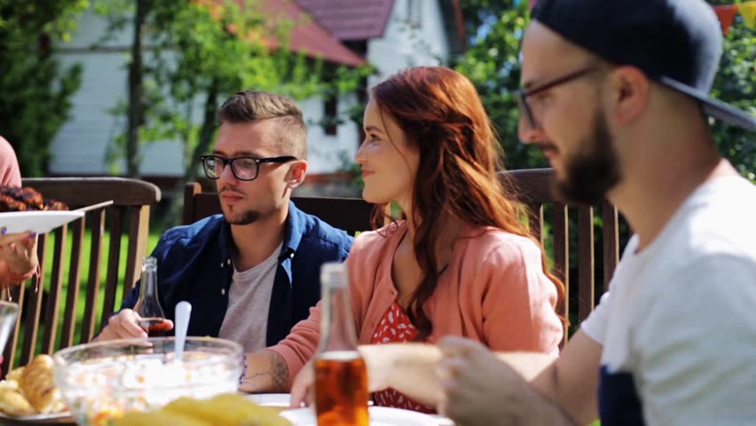 Leisure, holidays, eating, people and food concept - happy friends having dinner at summer garden party | Shutterstock HD Video #20117980