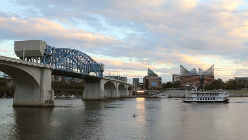 A riverboat travels east on the Tennessee River past the Tennessee Aquarium and a lone kayaker toward the Market Street Bridge in late afternoon in Chattanooga, Tennessee.