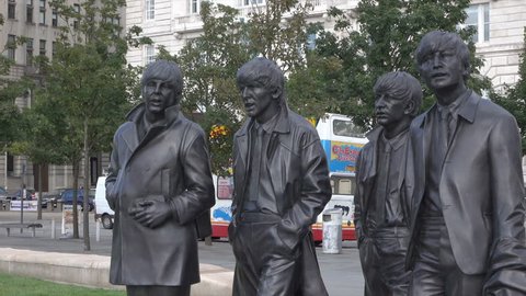LIVERPOOL, MERSEYSIDE/ENGLAND - SEPTEMBER 16, 2016: Tilt up to Statue of The Beatles at Pier Head. The statues were sculpted by Andrew Edwards and donated by the famous Cavern Club where they played.