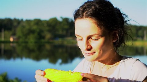 Beautiful girl is eating a boiled corn