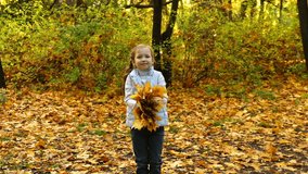 Footage girl throws up autumn leaves in the park. HD video. slow motion 120 fps