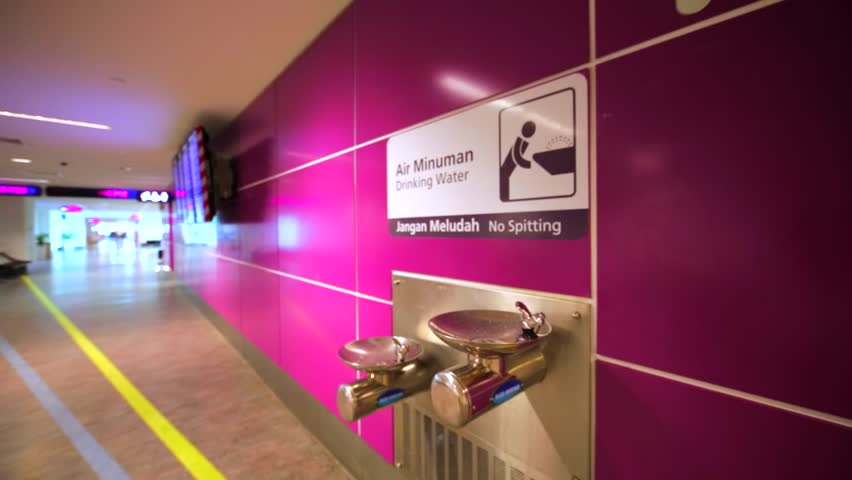Drinking water in Kuala Lumpur International airport. Man