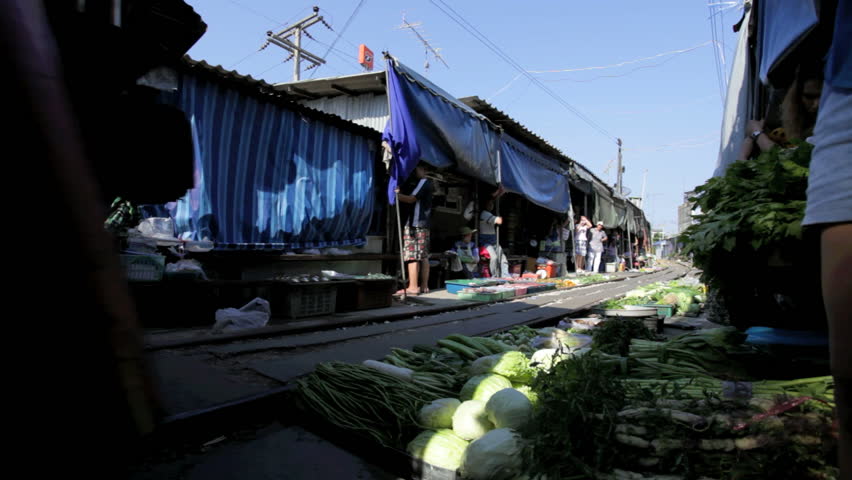 MAEKLONG, THAILAND - FEBRUARY 25: A train is going through the food market of