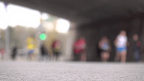 Blurred city marathon runners running under the bridge. Competition concept. 4K background bokeh video