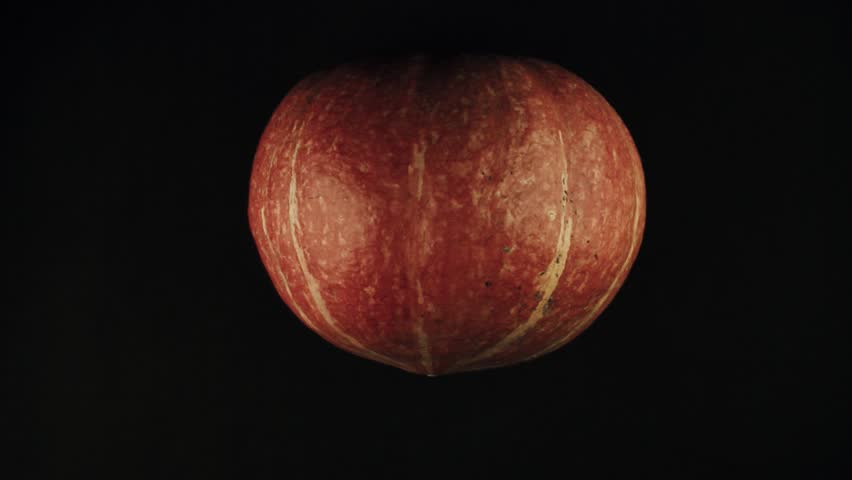 Male hands draws scary face jack o lantern on a pumpkin black surface POV
