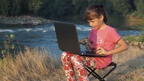 Girl with a laptop near a river
