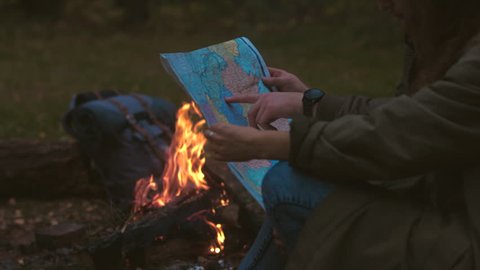 CINEMAGRAPH - Hikers couple studying the map near bonfire. Motion photo seamless loop. 4K UHD RAW edited footage