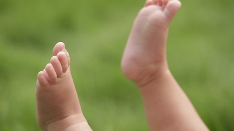 feet of the newborn in the grass