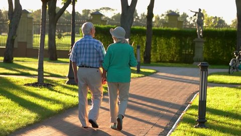 Senior couple walking in slo-mo. Elderly people hold hands. Respect past and cherish present. We are grateful to fate.