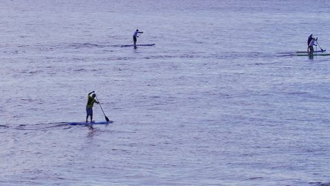 Gold Coast, Queensland, Australia - October 5, 2016 - An unidentified group paddles their stand up paddle boards out from and past Burleigh Heads on the Gold Coast, in the early morning. 