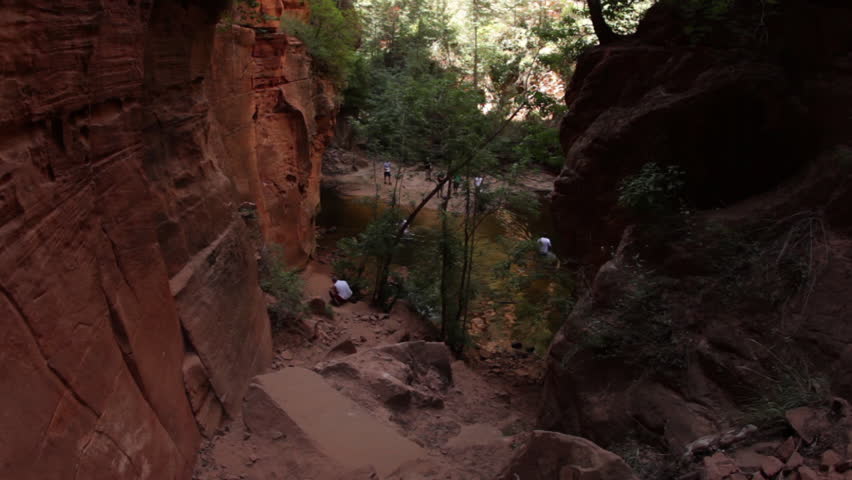 A hiker descending a cliffy path